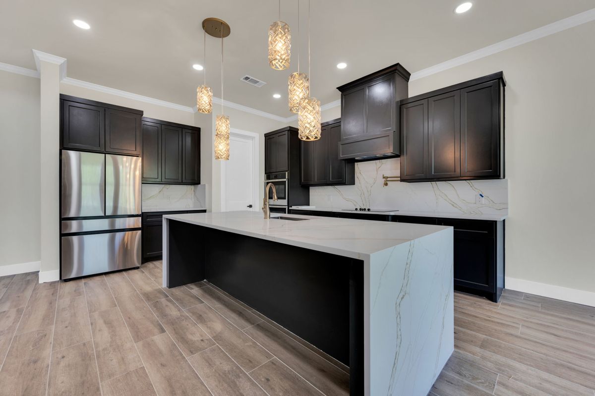 Kitchen with dark cabinets and a waterfall island